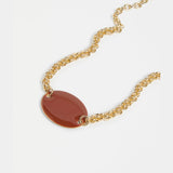 Elk Innfellt necklace with spice-colored pendant featuring intricate design on a silver chain.