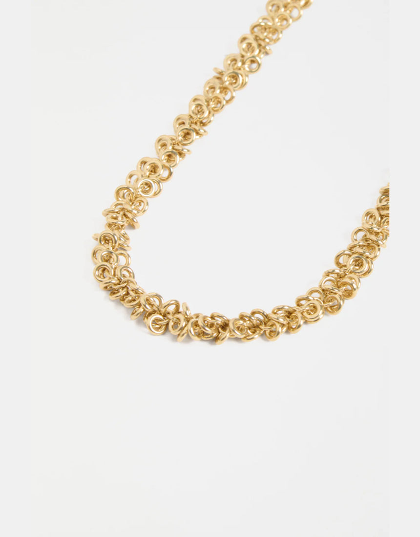 Gold Elk Hava Necklace with intricate chain and pendant, showcasing elegant design on a neutral background.