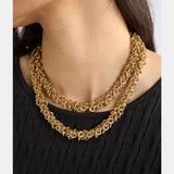 Gold Elk Hava Necklace featuring a delicate chain and intricate pendant design, displayed on a neutral background.