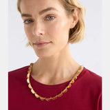 Elk Fossen Necklace in gold, featuring a delicate chain and elegant pendant, displayed on a neutral background.
