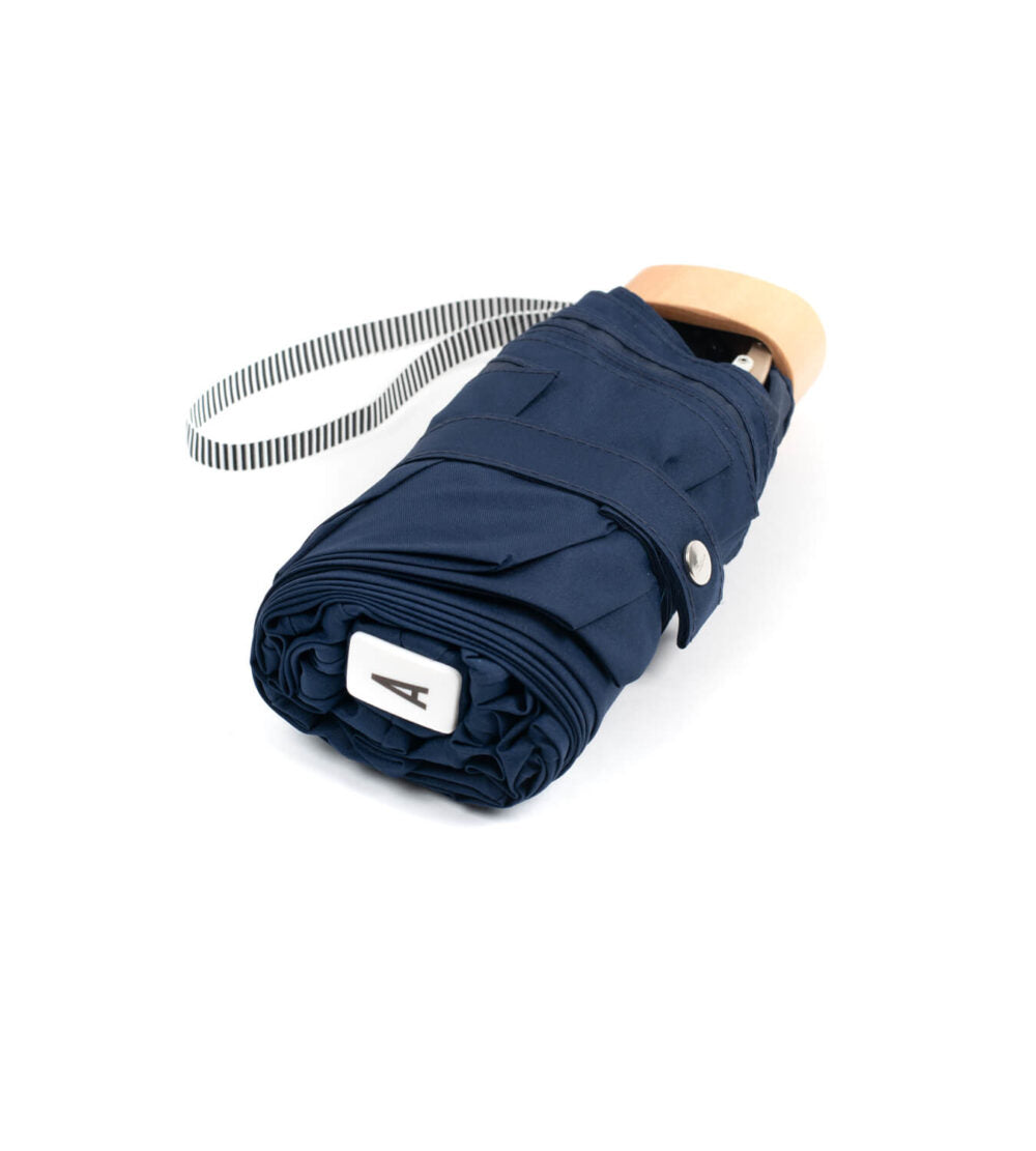 Anatole Colette navy blue micro-umbrella open, lightweight compact umbrella with a curved handle and navy blue canopy.