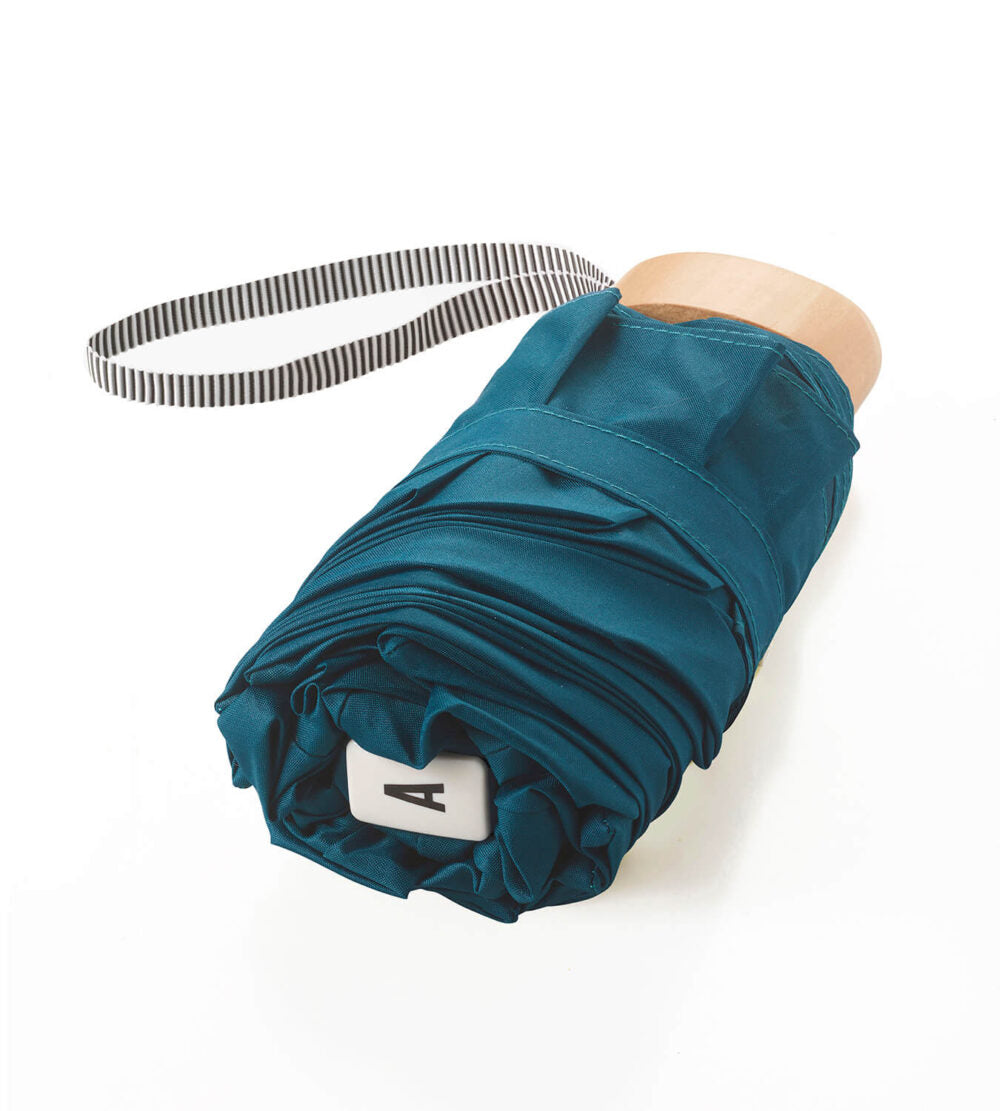 Anatole Octave Micro-Umbrella in mineral blue, compact closed umbrella with a sleek fabric cover and sturdy handle.