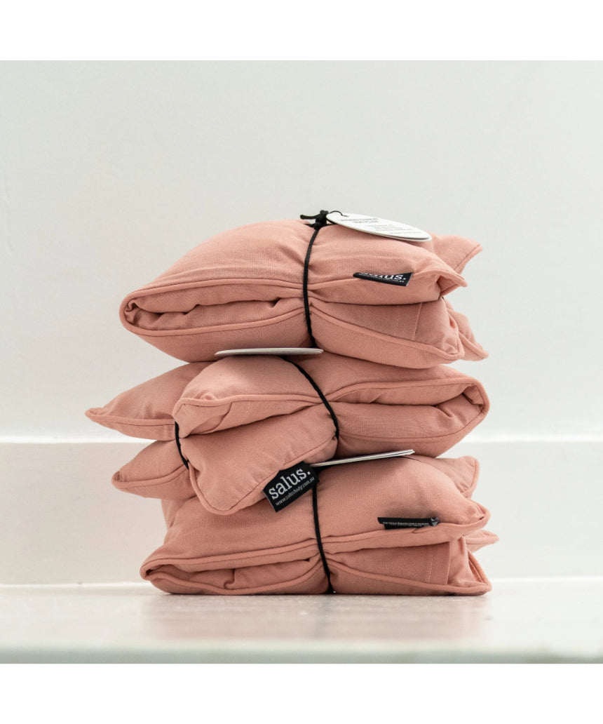 Salus Lavender & Barley heat pillow in blush, square-shaped bath and body product with soft pink fabric and plush texture.