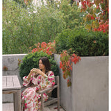 Bonnie and Neil Lupin Multi Linen Robe set styled in a bedroom with the robe draped over a bed, showcasing soft fabric and colorful pattern.