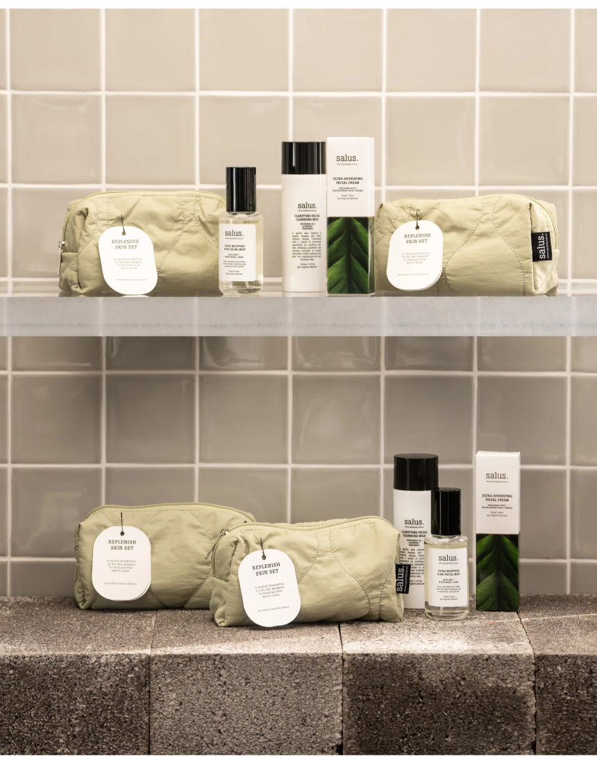 Salus Replenish Skin Set with skincare products, featuring bottles and jars in a natural setting for healthy, hydrated skin.