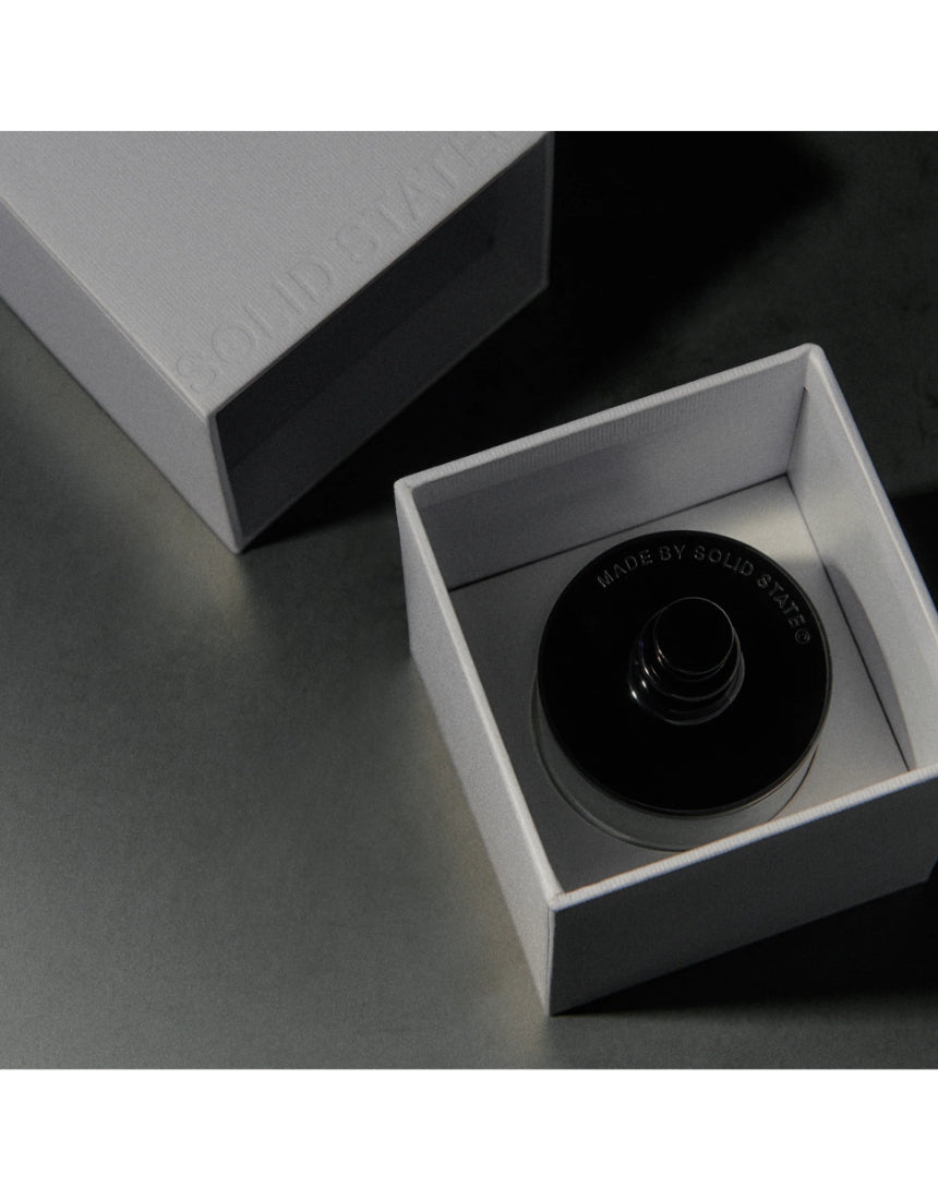 Solid State Wayfarer Extrait de Parfum cologne bottle with sleek black and silver design on a white background.