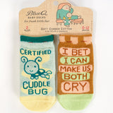 Blue Q baby socks featuring Cuddle Bug and Cry Baby designs, soft and colorful knit socks for infants.