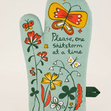 Blue Q oven mitt featuring a colorful "Shitstorm" design, made of heat-resistant fabric for kitchen safety and style.