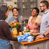 Blue Q oven mitt featuring colorful party in the kitchen design, made for safe handling of hot cookware.