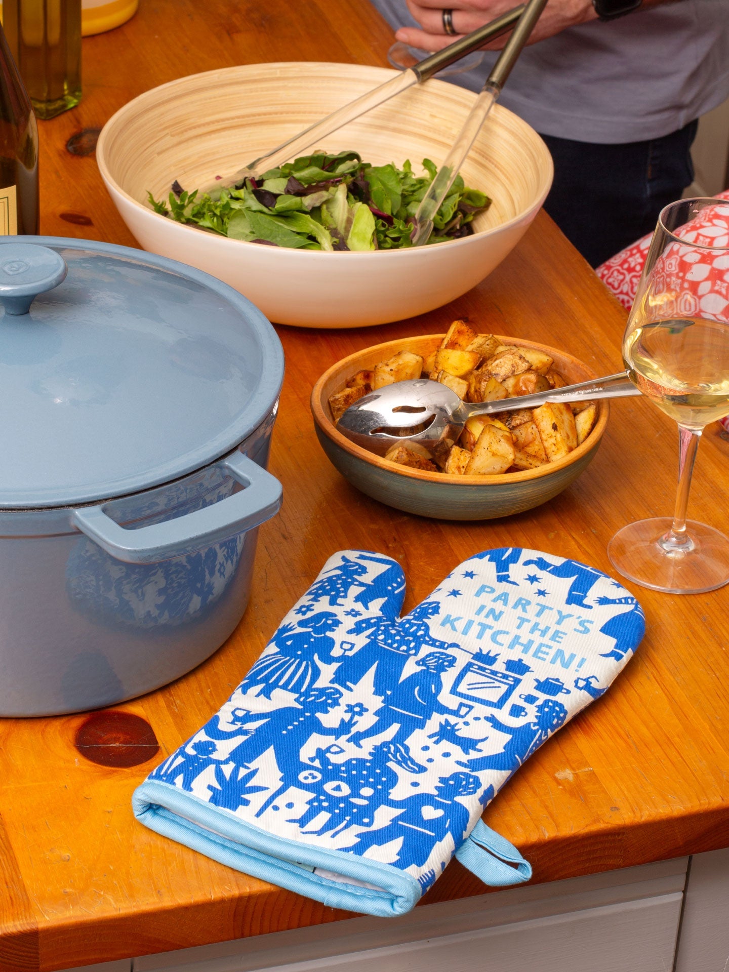 Blue Q oven mitt with colorful party in the kitchen design, heat-resistant fabric for cooking and baking protection.