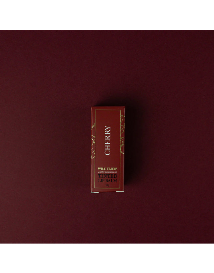 Cherry tinted lip balm by Wild Emery in a sleek tube, showing the smooth, glossy balm with a hint of cherry color.