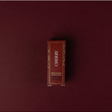 Cherry tinted lip balm by Wild Emery in a sleek tube, showing the smooth, glossy balm with a hint of cherry color.