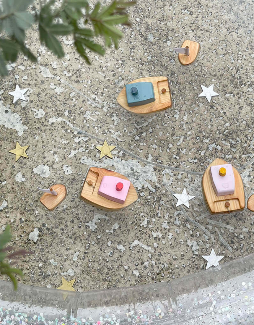 Pink Ofune wind-up boat for kids by Axis Toys, shown floating on water with detailed pink and white design.