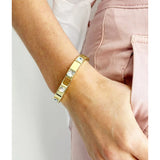 Gold Queenie bracelet by Mosk Melbourne featuring a sleek, elegant design with blue gemstone accents.