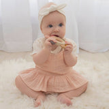 Living Textiles multi-surface teething wheel in rose color, featuring textured silicone and soft fabric for soothing baby teething.