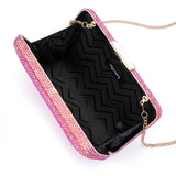 Olga Berg Edith iridescent pink clutch bag with a sleek, shiny finish and metallic accents on a plain background.