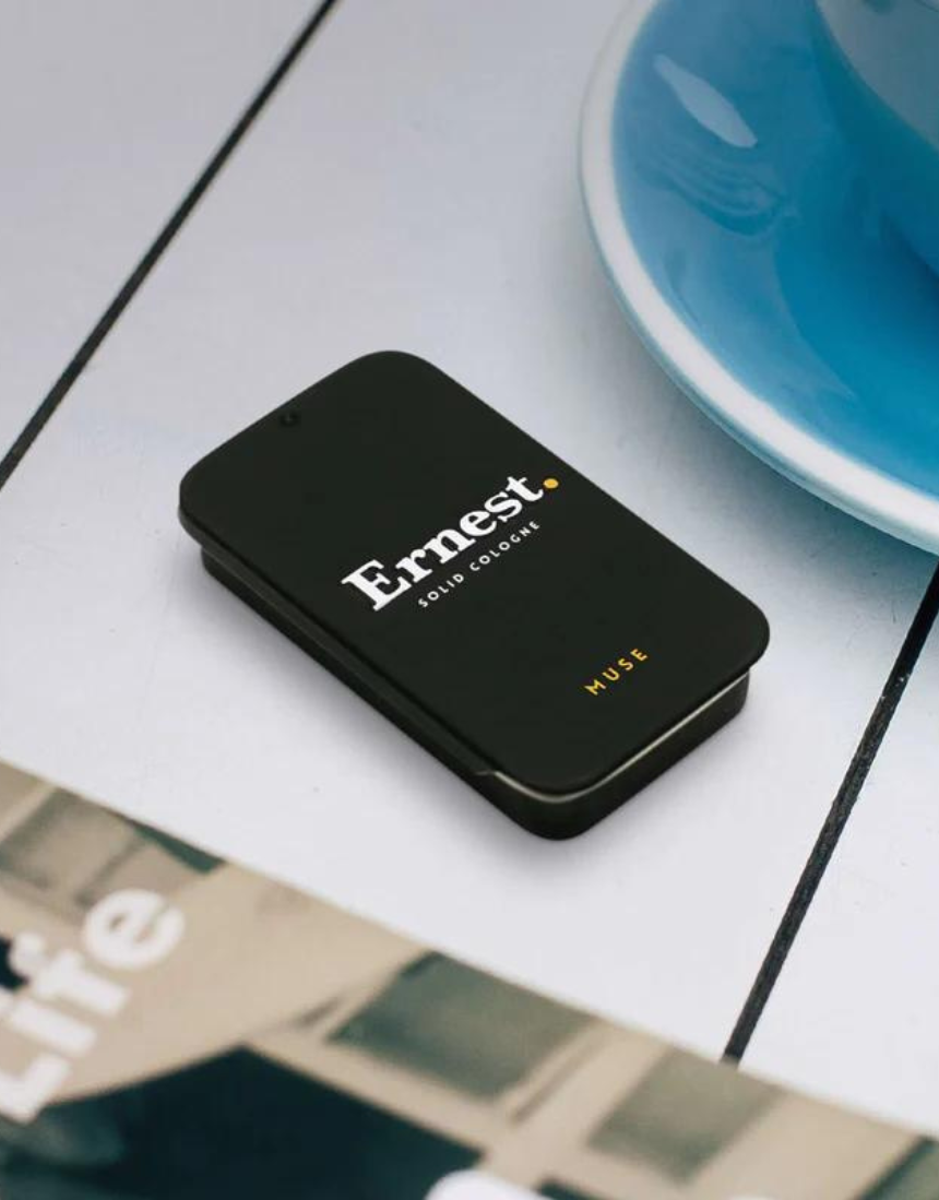 Ernest Muse solid cologne in a sleek container, featuring a minimalist design and a smooth, solid fragrance surface.