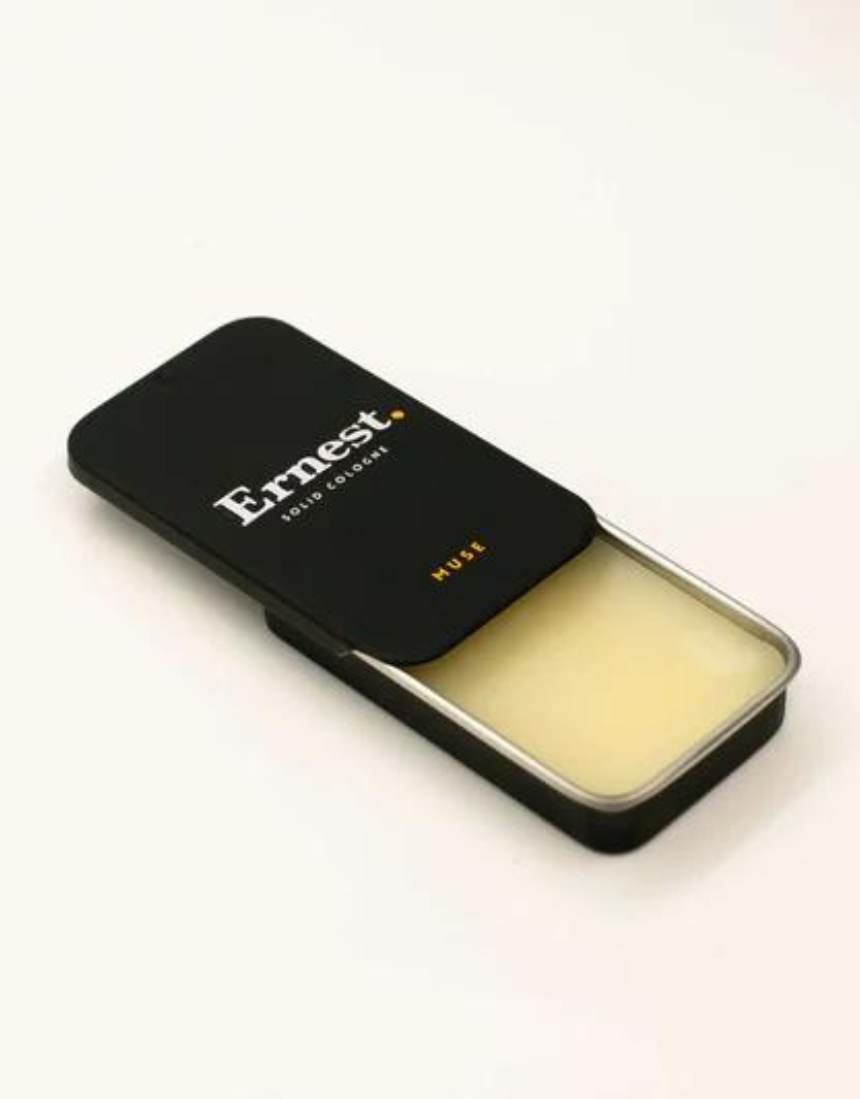 Ernest Muse Solid Cologne in a sleek, black jar with a smooth, rounded lid, showcasing the stylish packaging and product texture.
