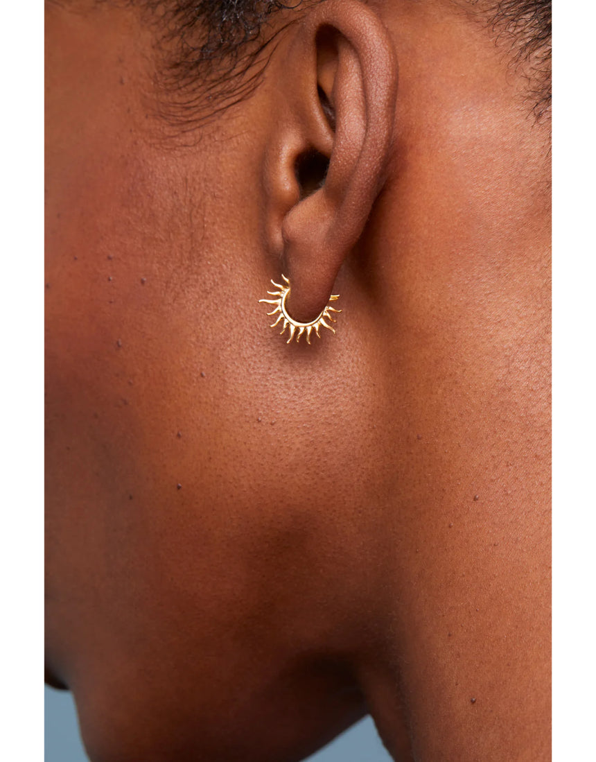 Estella Bartlett Sun Huggie Hoop Earring, gold-toned jewelry with sun design, close-up of stylish earring on white background