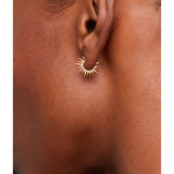 Estella Bartlett Sun Huggie Hoop Earring, gold-toned jewelry with sun design, close-up of stylish earring on white background