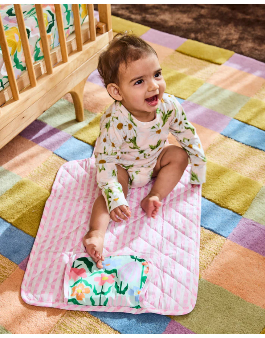 Kip & Co green baby change mat with colorful floral pattern, soft padded surface for comfortable diaper changes.