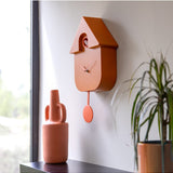 Terracotta Fisura cuckoo clock with wooden details and a traditional design, showcasing the clock face and cuckoo bird opening.