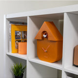 Terracotta Fisura cuckoo clock with wooden details and traditional design, hanging on a wall.