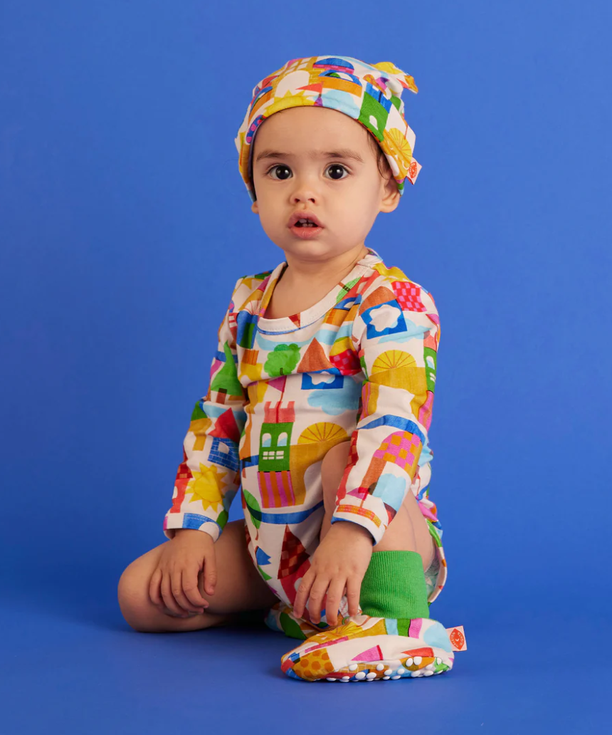 Baby long sleeve bodysuit by Halcyon Nights featuring a whimsical castle of dreams design for newborns aged 0-3 months.