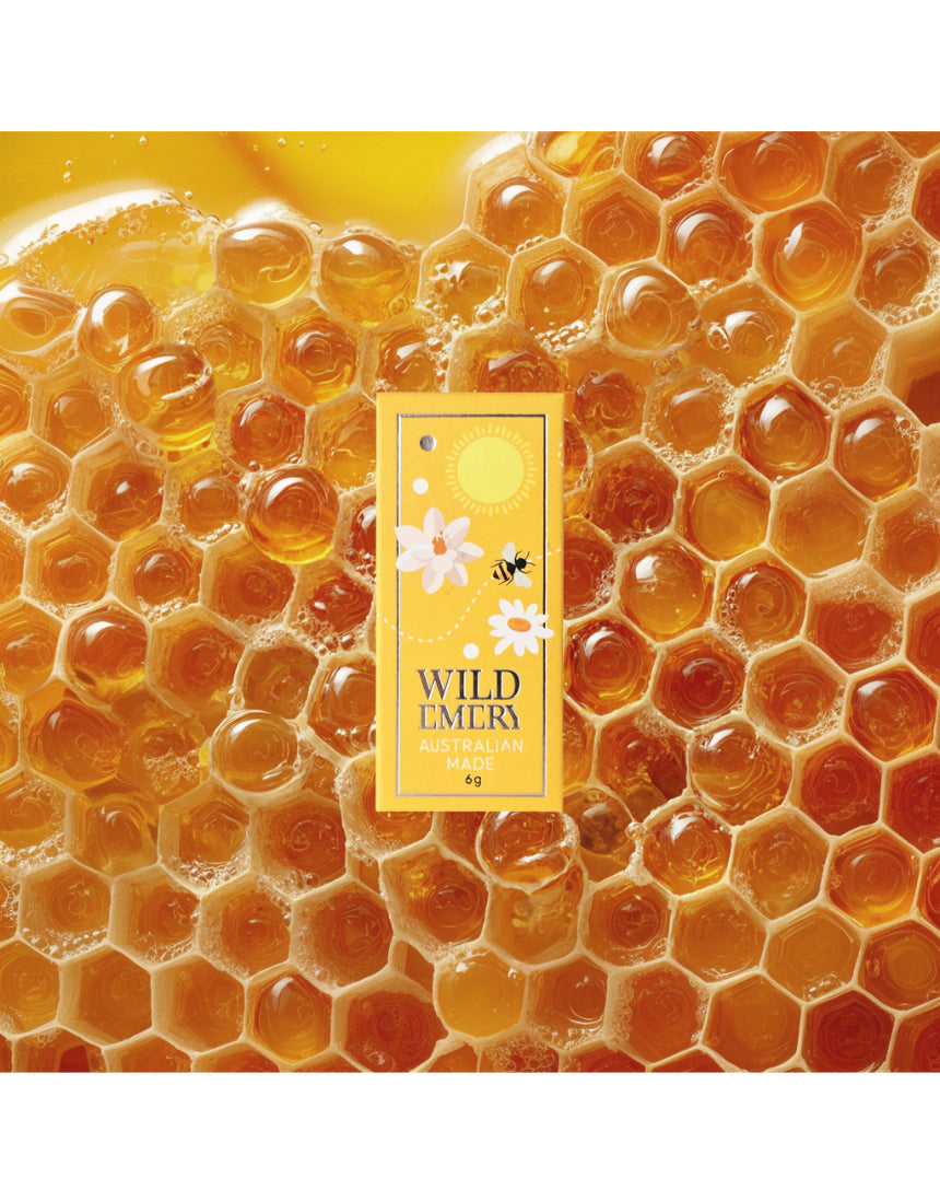Wild Emery Honey Mini Lip Balm in honey-colored lipstick tube, featuring natural honey-inspired packaging.