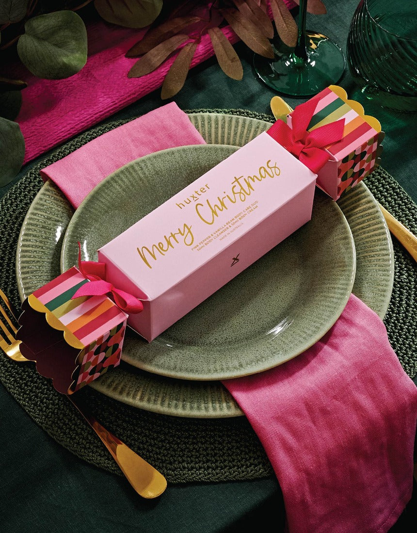 Huxter Christmas Body Care Gift Set with pink pepper and vanilla bean, featuring a festive decorated gift box and body care products.