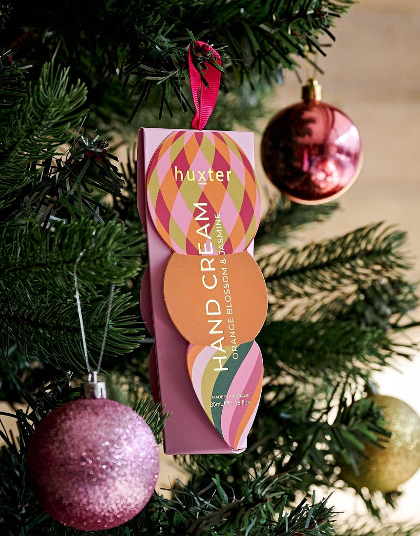 Huxter Adorned Christmas Hanging Hand Cream in soft pink, featuring decorative holiday packaging and a festive design.
