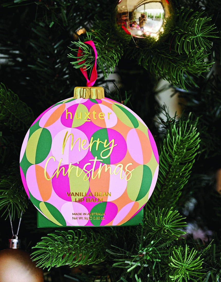 Huxter Adorned Christmas Hanging Lip Balm in green, decorative holiday-themed lip balm with hanging string, festive season skincare.
