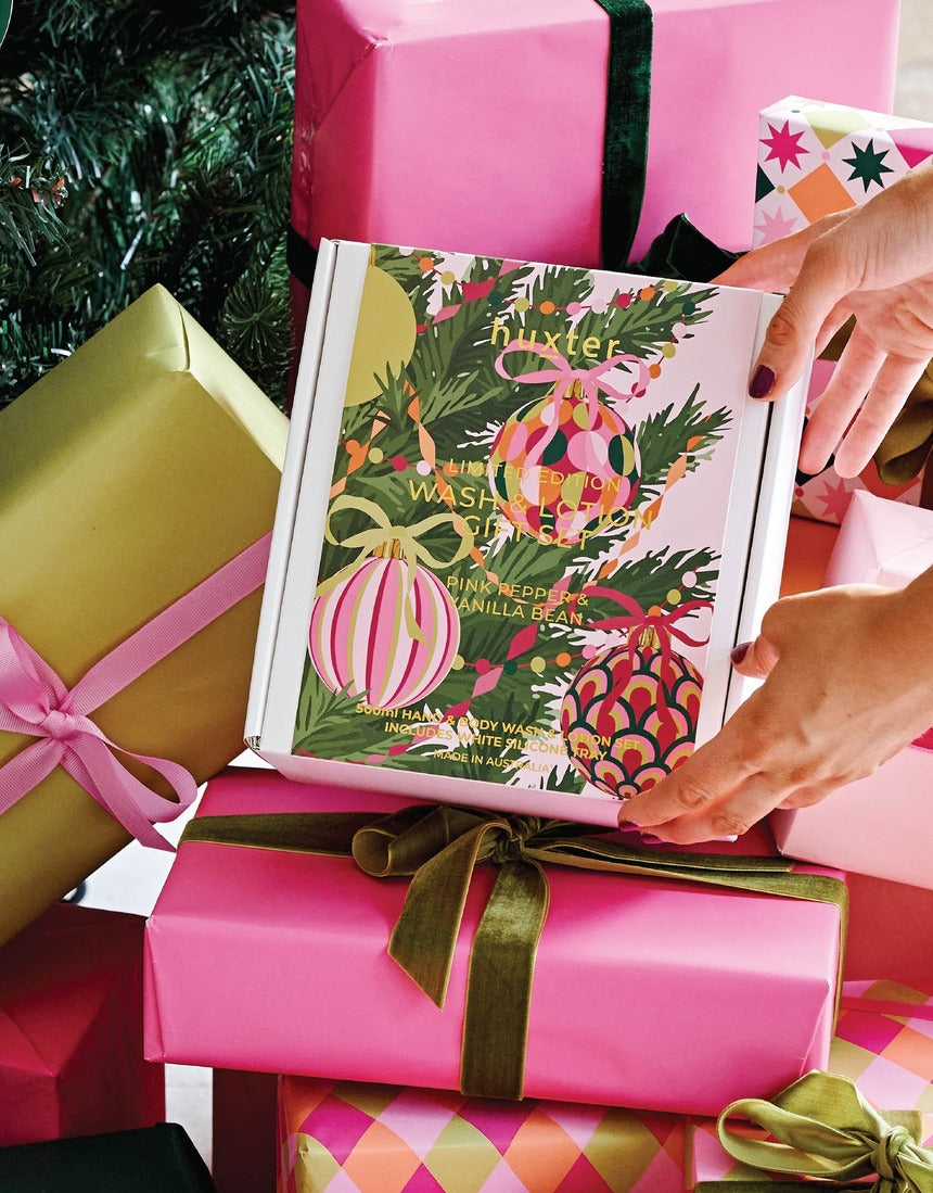 Huxter Adorned Christmas Bath & Body Gift Set with Pink Pepper and Vanilla Bean, includes wash and lotion bottles with holiday packaging.