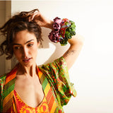 Set of Sage x Clare Delphine silk scrunchies featuring vibrant, patterned fabrics on a neutral background.