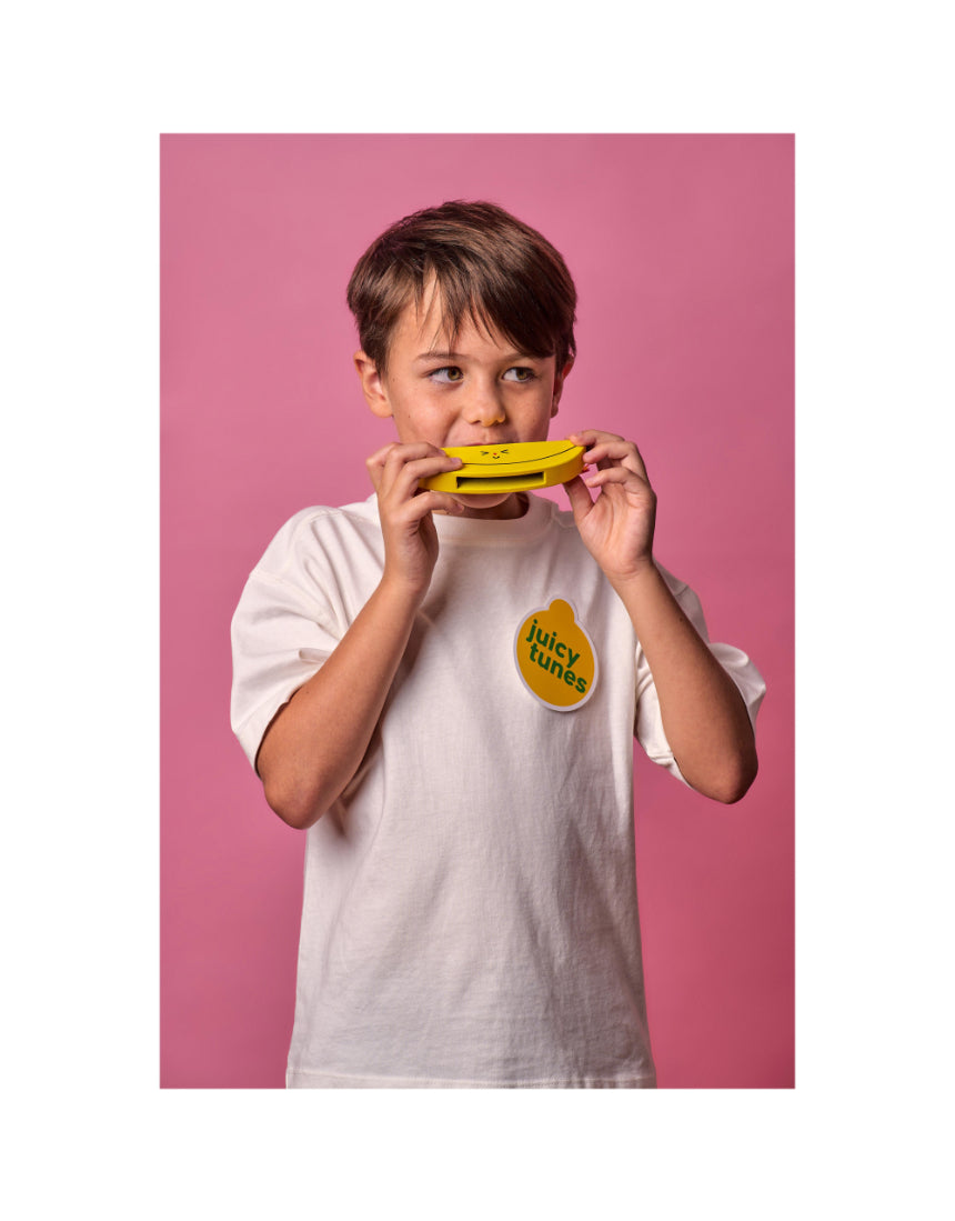 Child playing wooden fruit harmonica by isAlbi, showing a colorful, handcrafted musical instrument for kids.