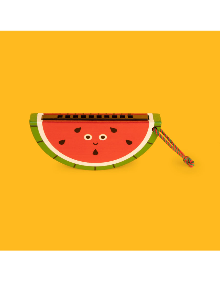 Wooden fruit harmonica by isAlbi, shown in a child's hand, featuring colorful fruit-shaped design and polished wooden surface.