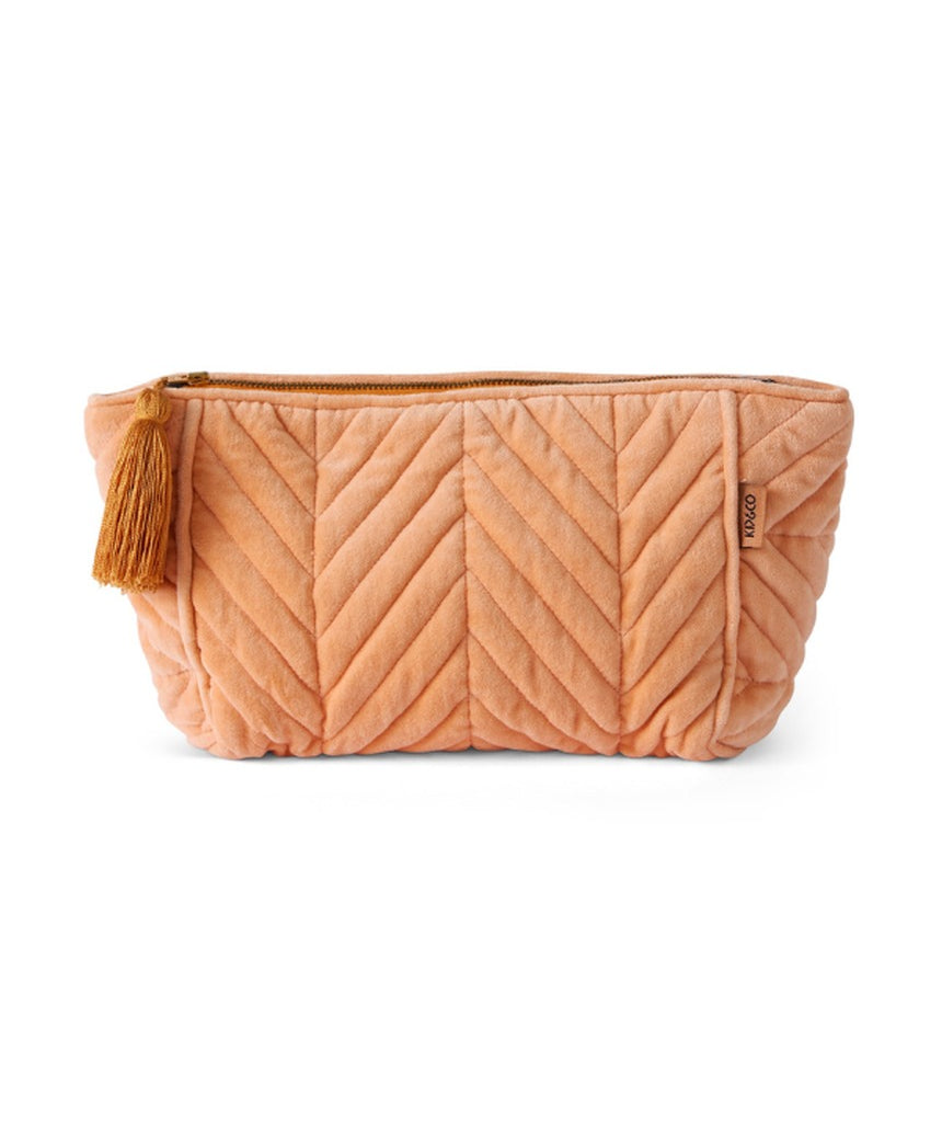 Kip&Co velvet toiletry bag in vibrant melon color, featuring a soft fabric exterior and spacious interior for travel essentials.