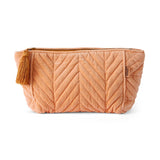 Kip&Co velvet toiletry bag in vibrant melon color, featuring a soft fabric exterior and spacious interior for travel essentials.