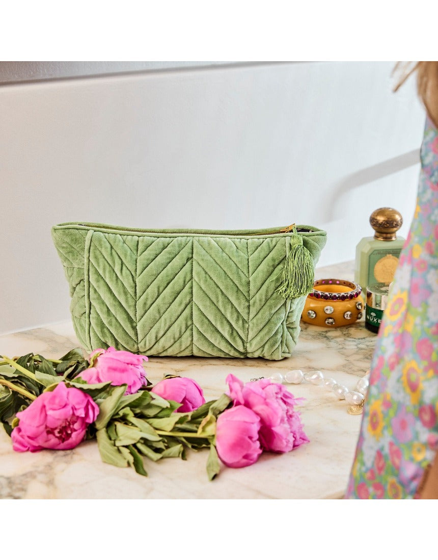 Kip&Co velvet toiletry bag in pesto green with a soft, plush texture, featuring a zip closure and compact design for travel toiletries.