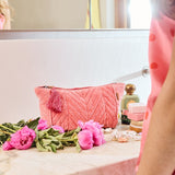 Kip&Co velvet toiletry bag in strawberry color with zipper closure and soft texture, designed for travel and organization.