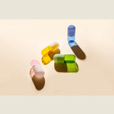 Maho Happi Pill glassware set featuring blue pill-shaped glasses on a white surface with decorative elements.