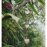 Matr Boomie Alaya Heart Trio Wind Chime with three hanging metal hearts and intricate design, hanging outdoors.