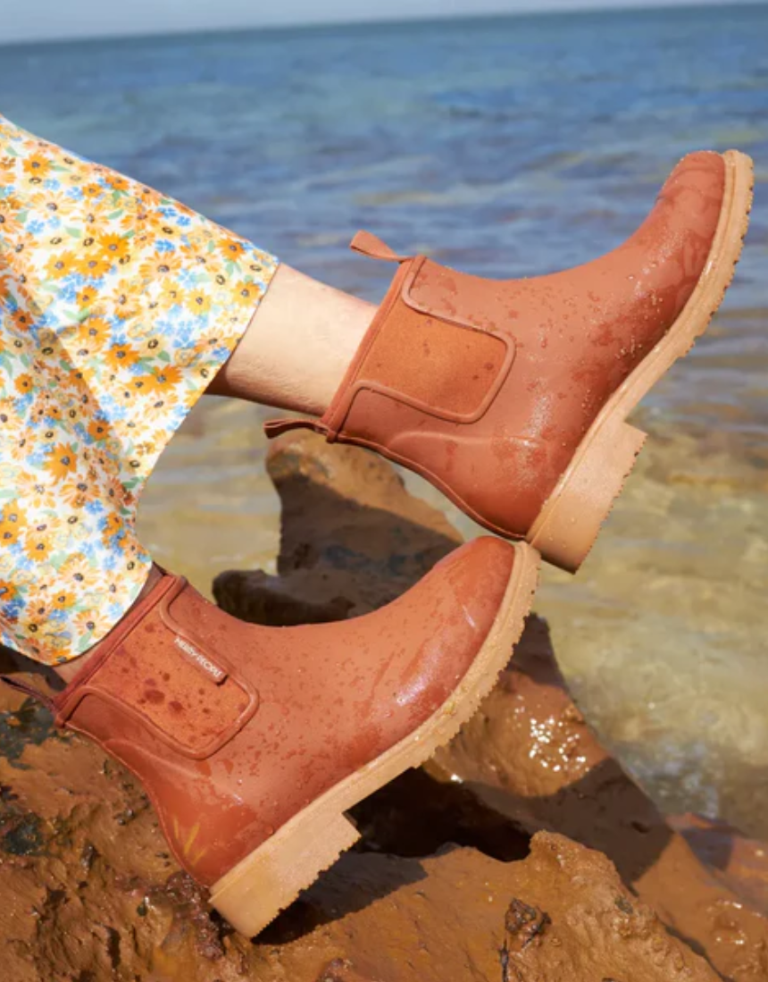 Rust-colored Merry People Bobbi Gumboot shoes with a sleek rubber design and sturdy soles, perfect for rainy weather.