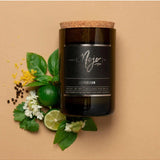Flatlay of Mojo Candle Co. Peppercorn Black Label candle with peppercorns and a wine bottle for a cozy, aromatic ambiance.