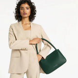 Green Status Anxiety Light Of Day handbag with adjustable strap and minimalist design, shown on a lifestyle background.