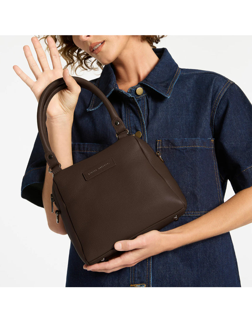 Status Anxiety Mini Mountains bag in cocoa color, stylish small leather handbag with adjustable strap and minimalist design.