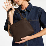 Status Anxiety Mini Mountains bag in cocoa color, stylish small leather handbag with adjustable strap and minimalist design.