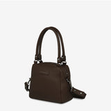 Status Anxiety Mini Mountains Bag in cocoa color, side front view showing compact bag with adjustable strap and mountain-inspired design.