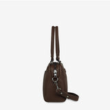 Status Anxiety Mini Mountains Bag in cocoa color, showing side view with mountain-inspired textured design and compact shape.