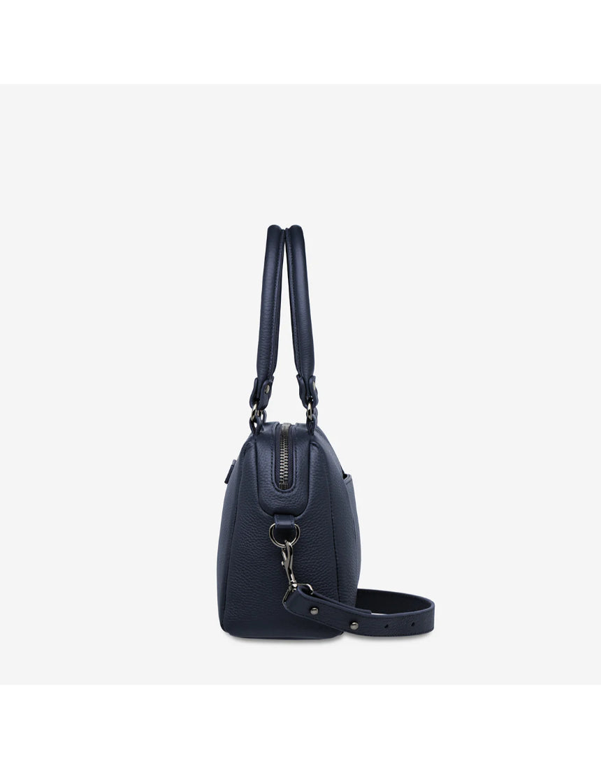 Status Anxiety Mini Mountains Bag in midnight blue shown from the side, featuring a compact, stylish bags design with a sleek finish.